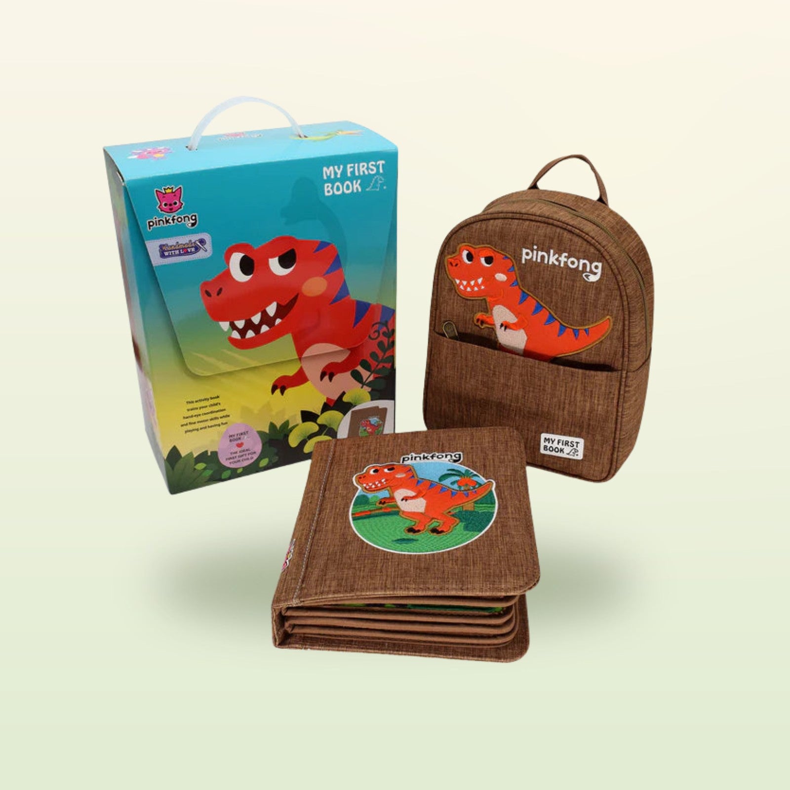 My First Book T-Rex Quiet Book mit Verpackung und passendem Dino-Rucksack auf sanftem Dschungelgrün-Hintergrund – ab 1 Jahr